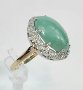 Gold ring with green gemstone and diamonds.