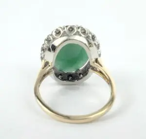 Gold ring with green gemstone and diamonds.