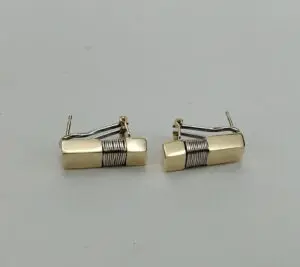 Gold and silver rectangular cufflinks on display.