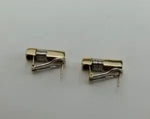 Two gold and silver clip-on earrings.