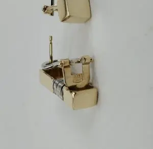 Gold earrings with geometric design.