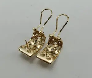 Gold earrings with intricate woven design.