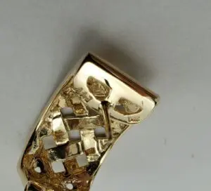 Gold belt buckle with intricate design.
