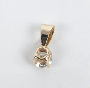 Gold pendant with clear gemstone setting.