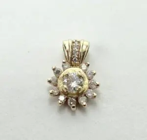Gold and diamond sunburst pendant on display.
