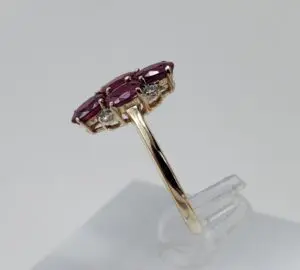 Gold ring with red gemstones displayed.