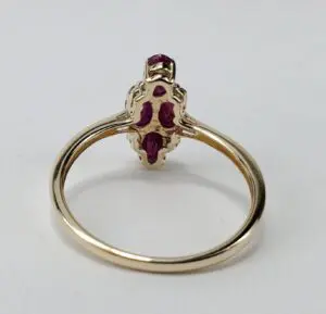 Gold ring with red gemstones, rear view.