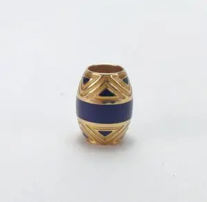 Gold and blue decorative bead on white.