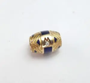 Gold and blue decorative bead with gemstone.