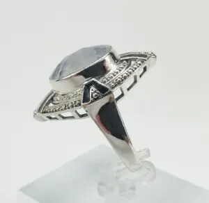 Silver ring with large gemstone and intricate design.