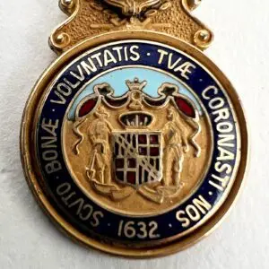 Gold emblem with Latin inscription and crest.