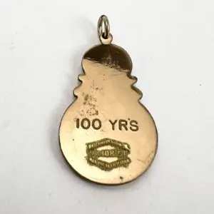 Gold snowman pendant with "100 YRS" inscription.