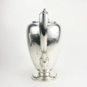 Silver teapot with a curved handle.