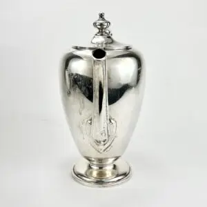 Silver teapot with ornate lid and spout.