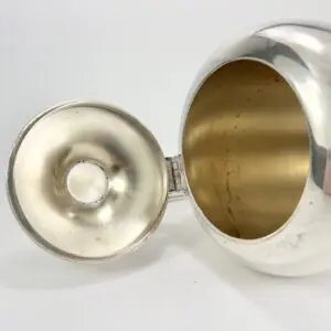 Open silver flask with cap beside.