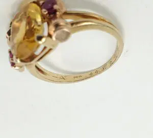 Gold ring with a large yellow gemstone.