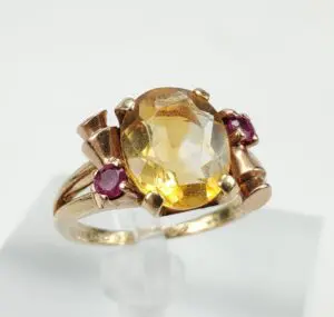 Gold ring with yellow and pink gemstones.