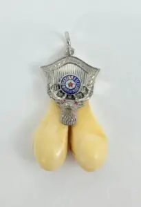 Pendant with tusks and ornate silver design.