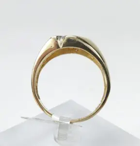 Gold ring displayed on a stand.