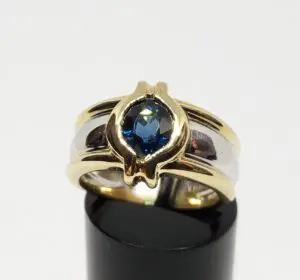 Gold ring with blue gemstone on display.