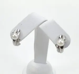 Pearl and diamond earrings on display stand.