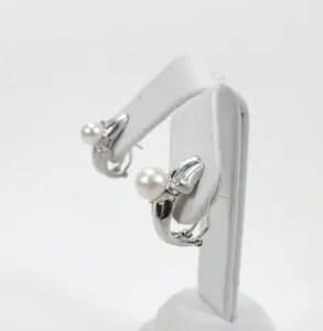 Silver earrings with pearl accents displayed.