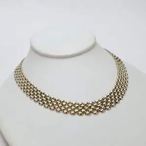 Gold chain necklace on display stand.