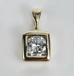 Gold pendant with large round diamond.