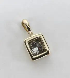 Gold pendant with square gemstone design.