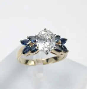 Gold ring with diamond and blue gemstones.