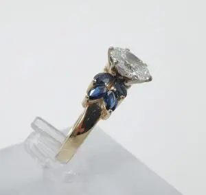Gold ring with diamond and blue gemstones.