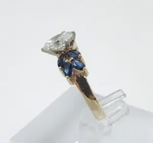 Gold ring with diamond and blue stones.