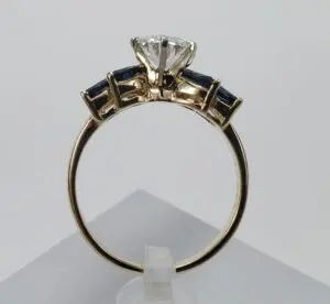 Gold ring with diamond and dark stones.