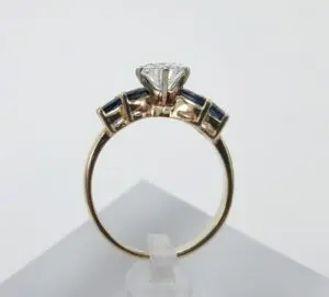Gold ring with gemstones and diamond setting.