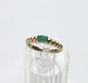 Gold ring with green oval gemstone.