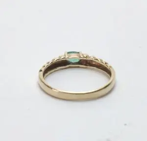Gold ring with small green gemstone.