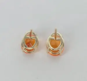 Gold earrings with orange gemstones on white.