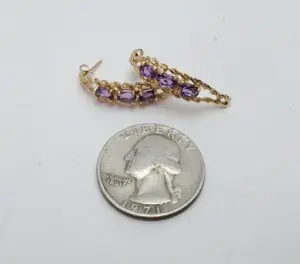 Gold earrings with purple stones, quarter coin.
