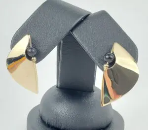 Gold earrings with black bead accents.