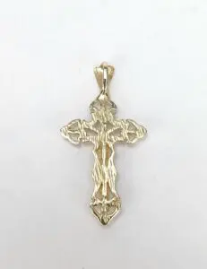 Gold cross pendant on white background.