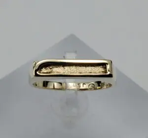 Gold ring with a textured rectangular design.