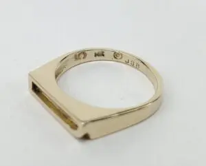 Gold ring with engravings on the band.