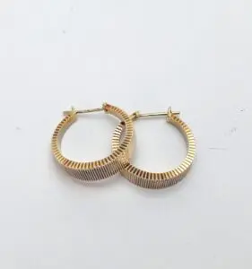 Gold hoop earrings on white background.
