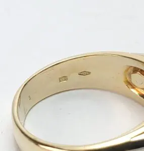 Gold ring with engraved hallmarks inside.