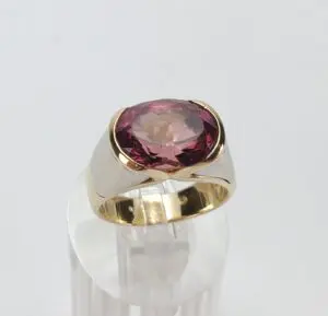Gold ring with large pink gemstone.
