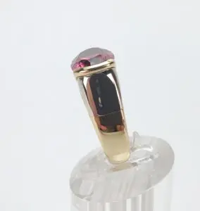 Gold ring with a red gemstone.