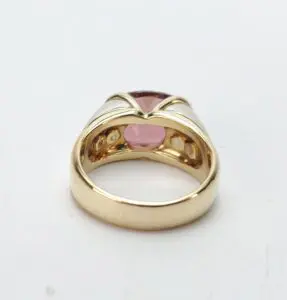 Gold ring with pink gemstone setting.
