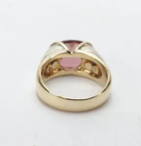 Gold ring with pink gemstone setting.