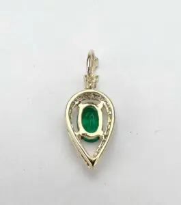 Gold teardrop pendant with green gemstone.