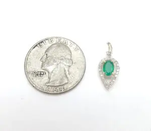 Quarter coin next to emerald pendant.